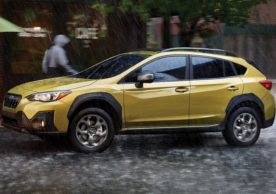 2023 Subaru Crosstrek Sport AWD Compact SUV In Plasma Yellow Pearl Driving Through The Rain - Feature Image