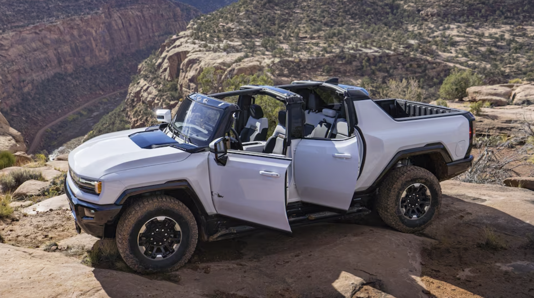 2024 GMC HUMMER EV Pickup Truck in white parking on top of a mountain