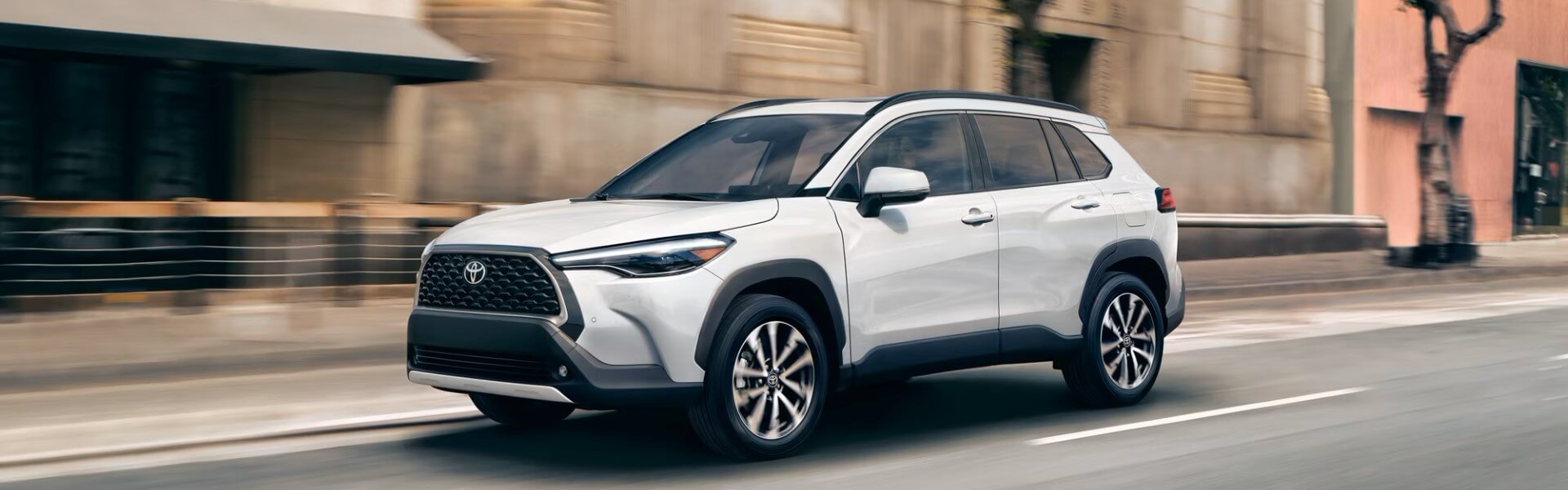 2024 Toyota Corolla Cross Hybrid in white running on street with side view-For Sale