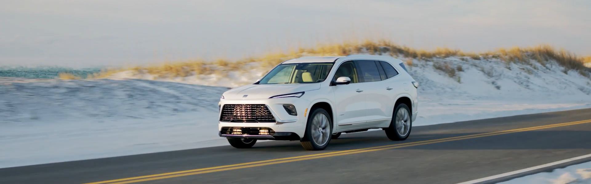 2025 Buick Enclave is white running with side view-Banner