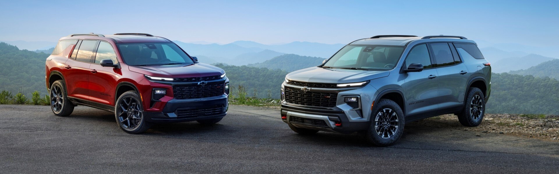 2025 Chevrolet Traverse RS And Z71 Parked On A Road With Mountains In The Horizon Banner