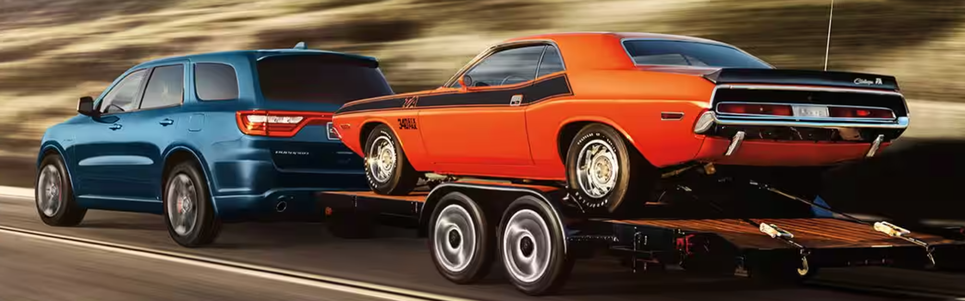 2025 Dodge Durango towing a classic orange muscle car on a flatbed trailer-For Sale