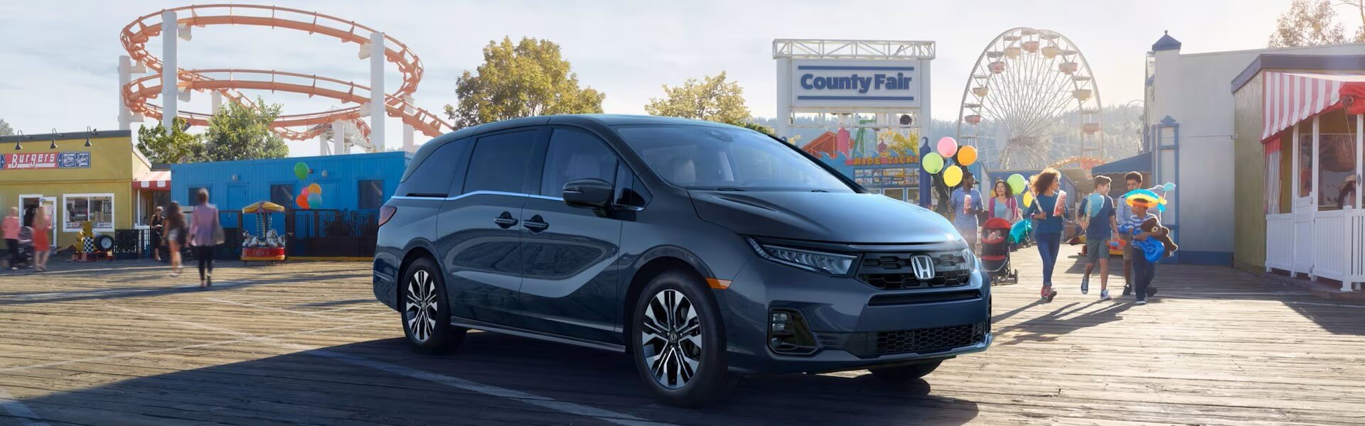 2025 Honda Odyssey Elite In Smoke Blue Pearl Parked At A Country Fair Banner