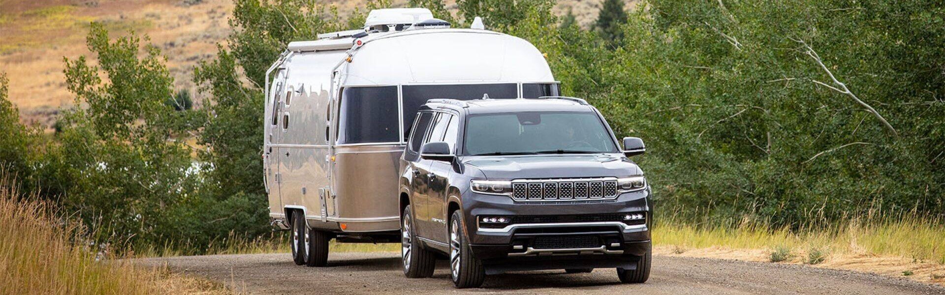 2025 Jeep Grand Wagoneer Traveling On A Country Road, Towing A Trailer For Sale