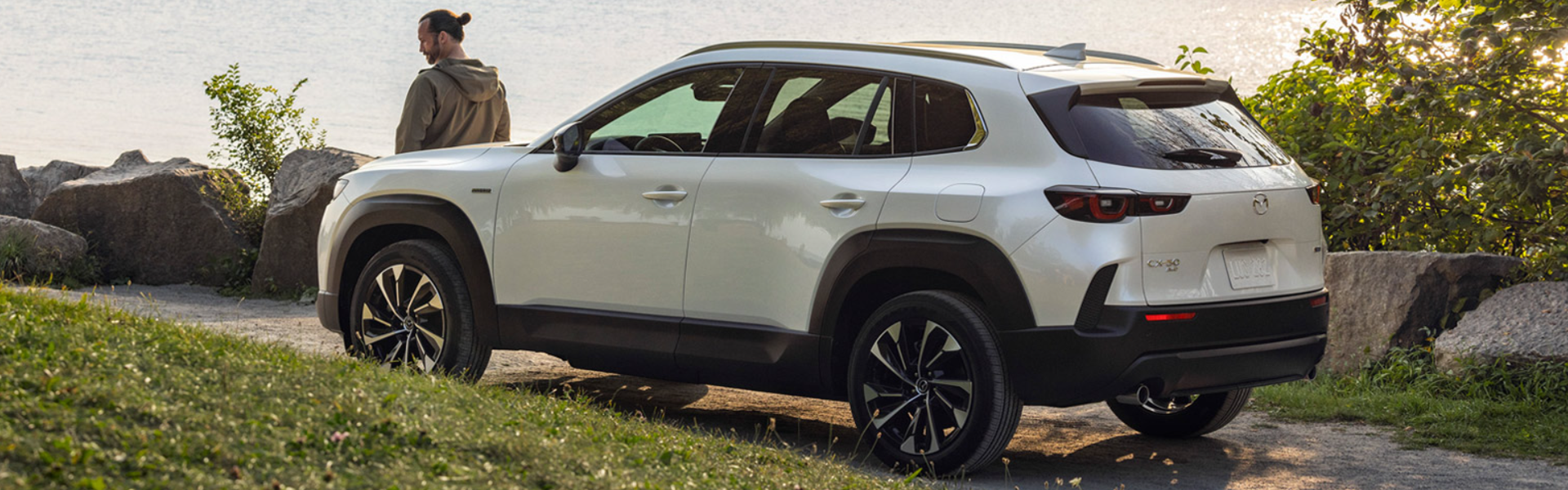 2025 Mazda CX-50 Hybrid in white parked with side and rear view-features