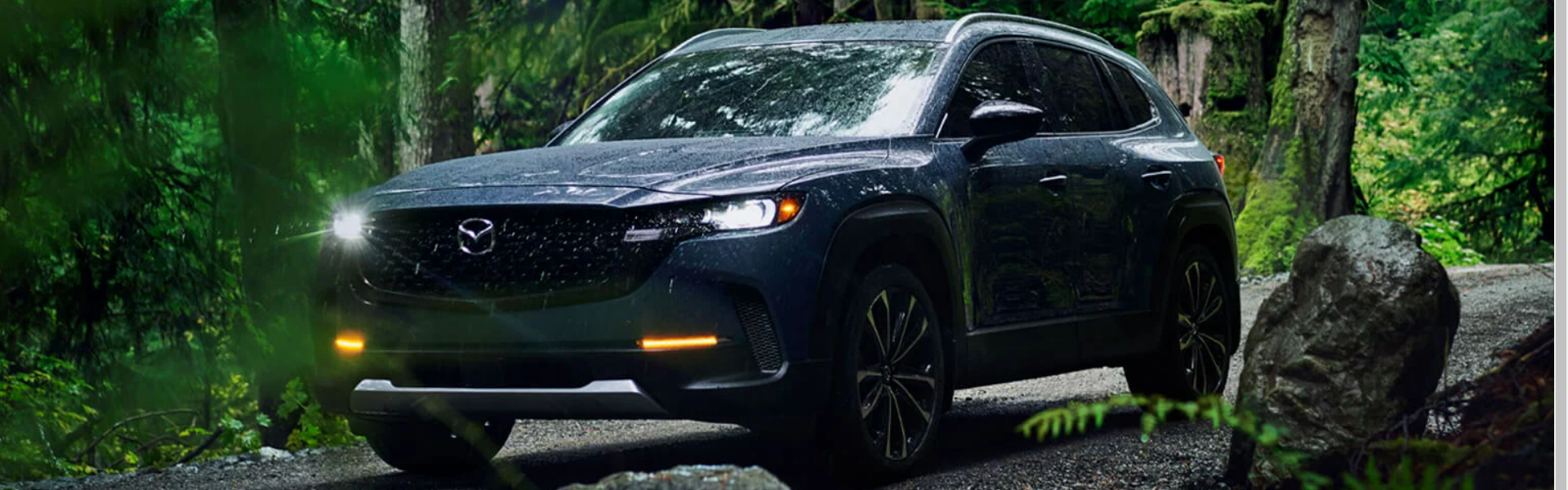 2025 Mazda CX-50 Parked On A Road In A Forested Area Banner