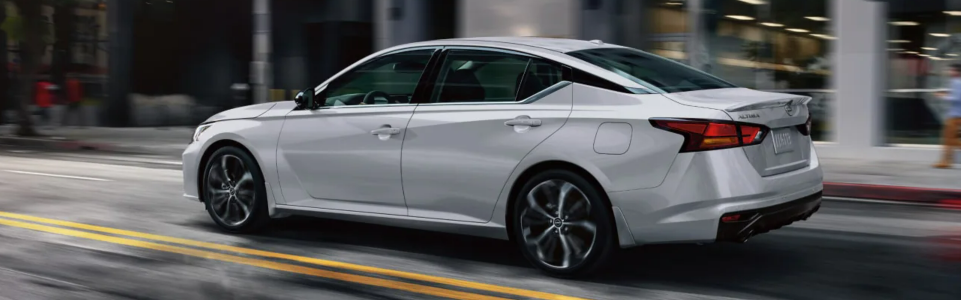 2025 Nissan Altima driving on a city street-Banner