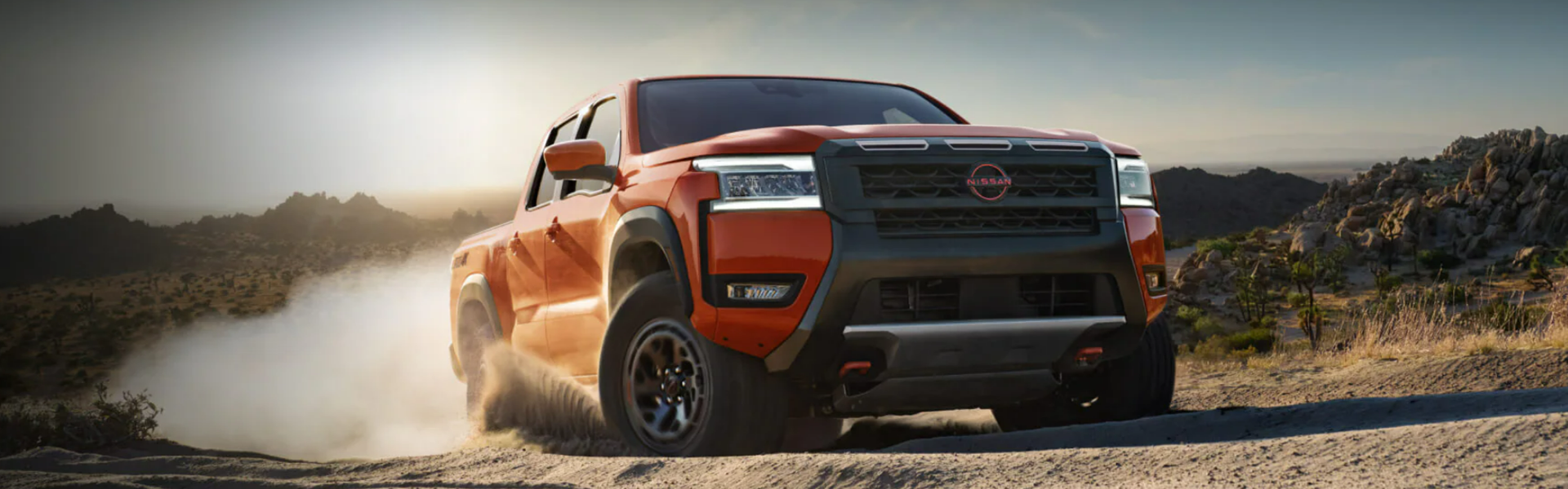 2025 Nissan Frontier driving through a desert-like terrain-For Sale