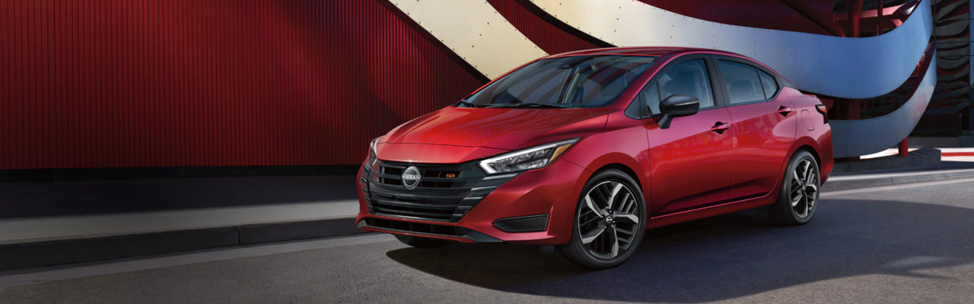 2025 Nissan Versa parked near an urban, stylized background-Banner