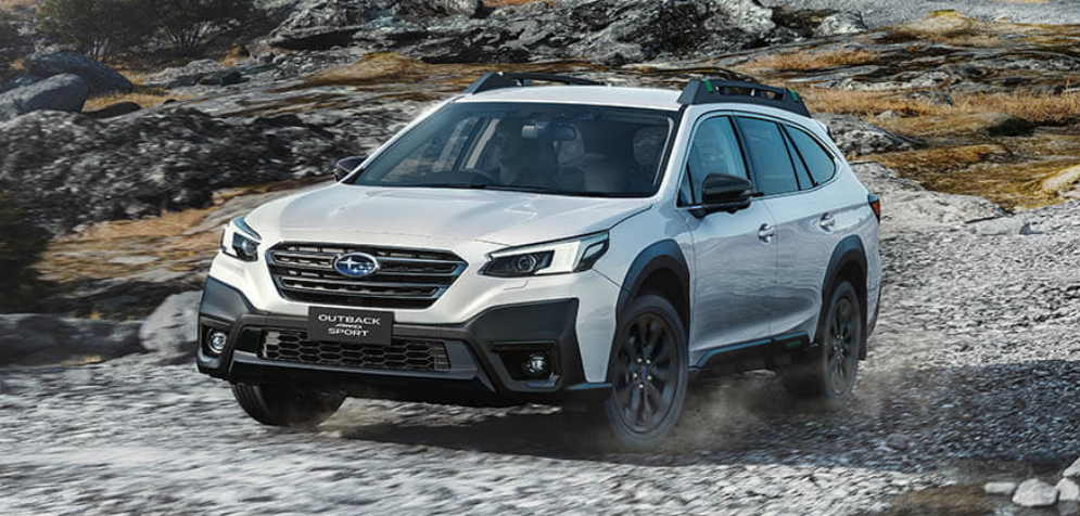 2025 Subaru Outback driving off-road on a rugged, rocky terrain