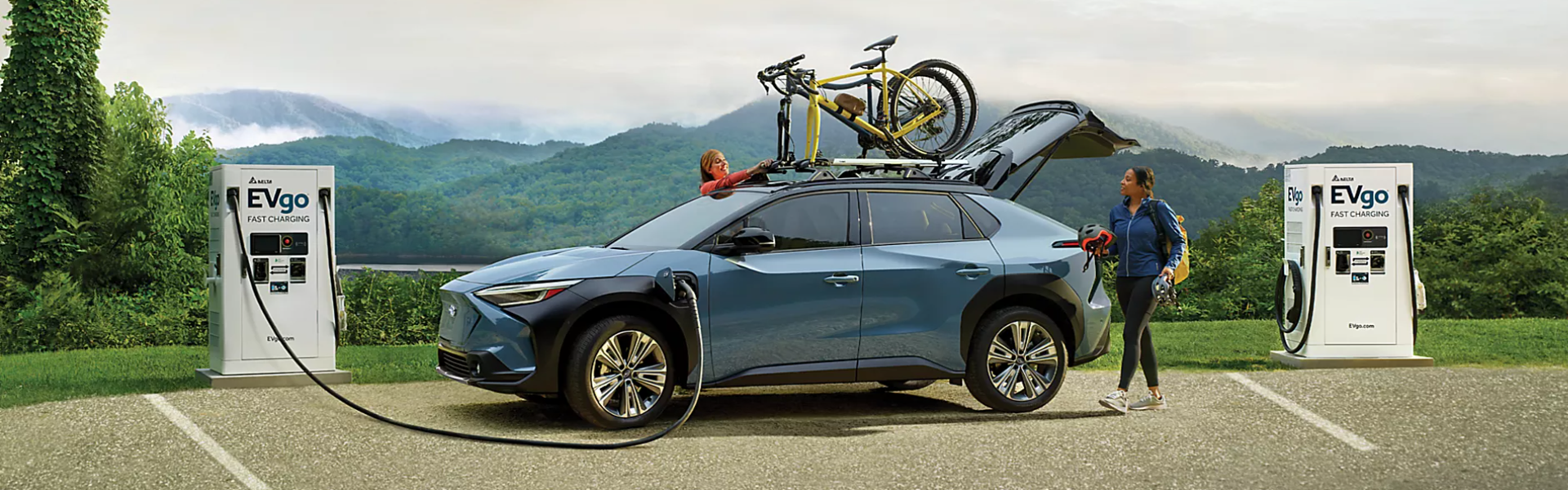 2025 Subaru Solterra charging at an EVgo fast-charging station in a scenic outdoor setting-Banner