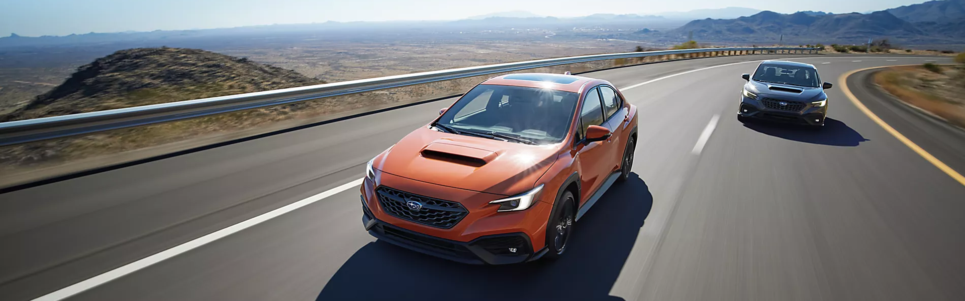 2025 Subaru WRX in orange running on street with front view-Banner