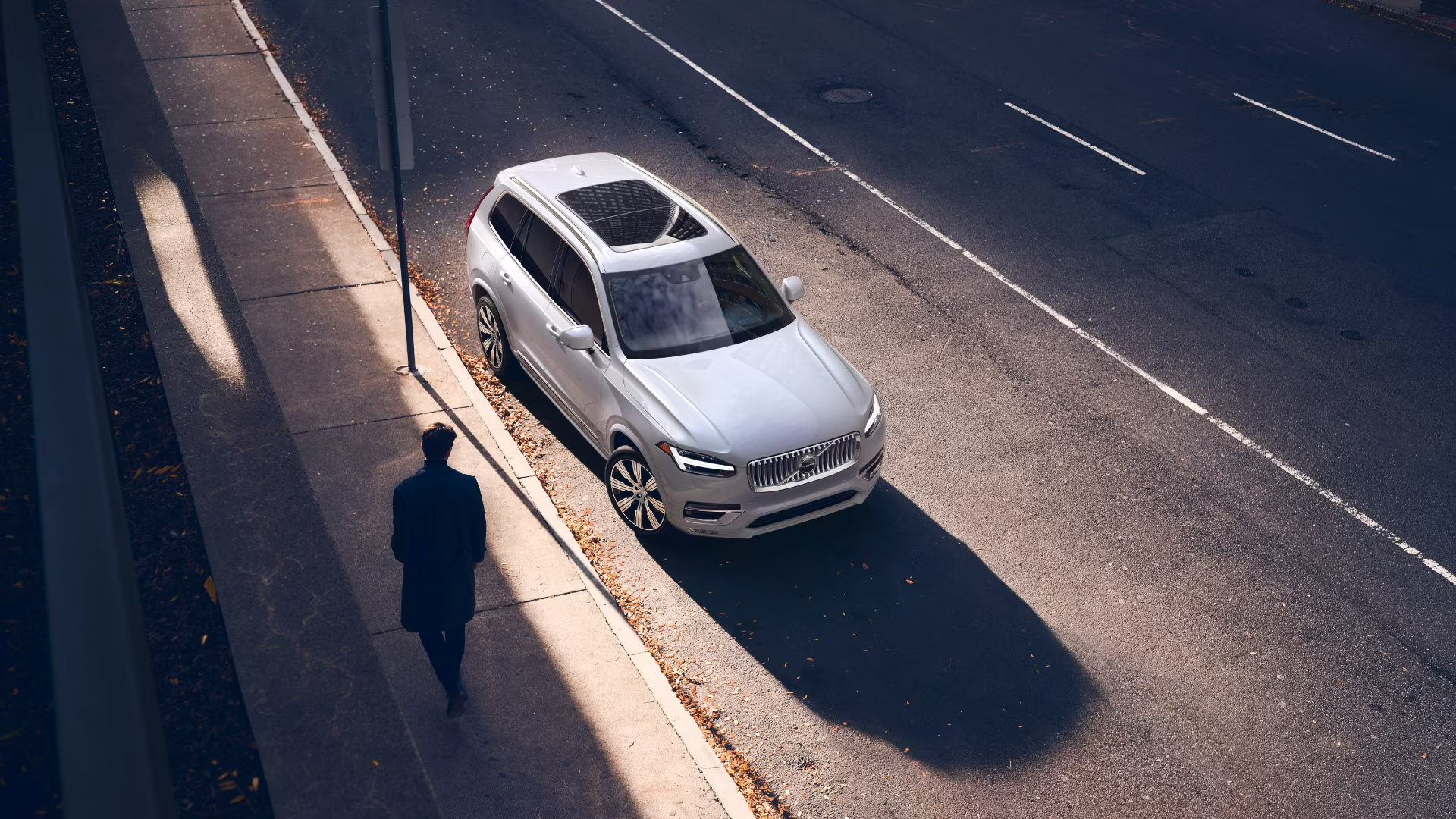 2025 Volvo XC90 parked along a city street, with a person walking on the sidewalk nearby-Features