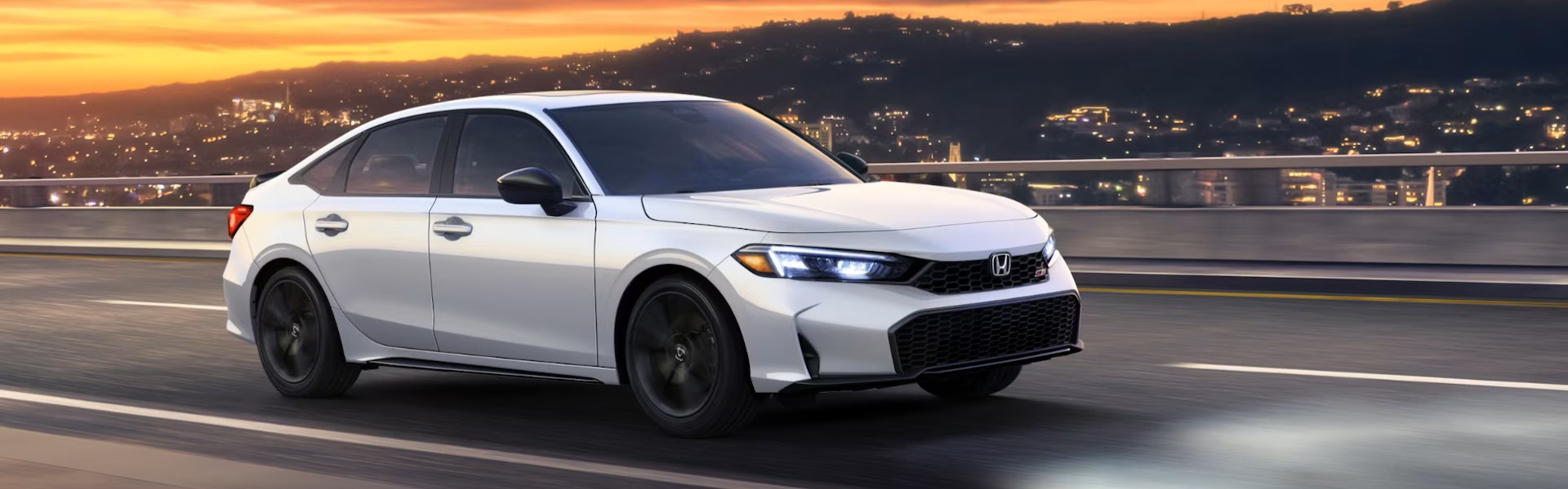 2026 Honda Civic Si driving on a city road Banner
