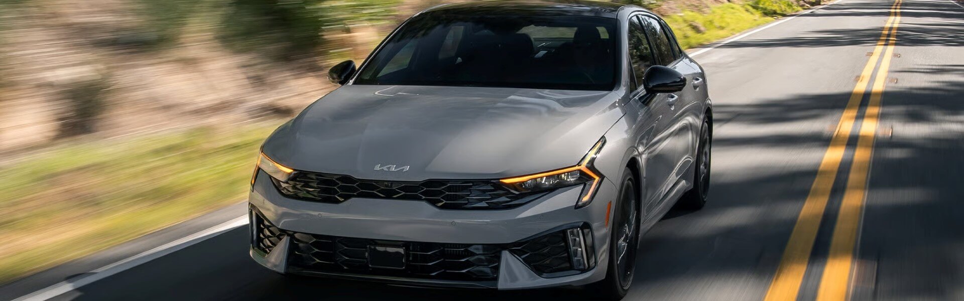 2026 Kia K5 On Deserted Road In The Mountains Banner
