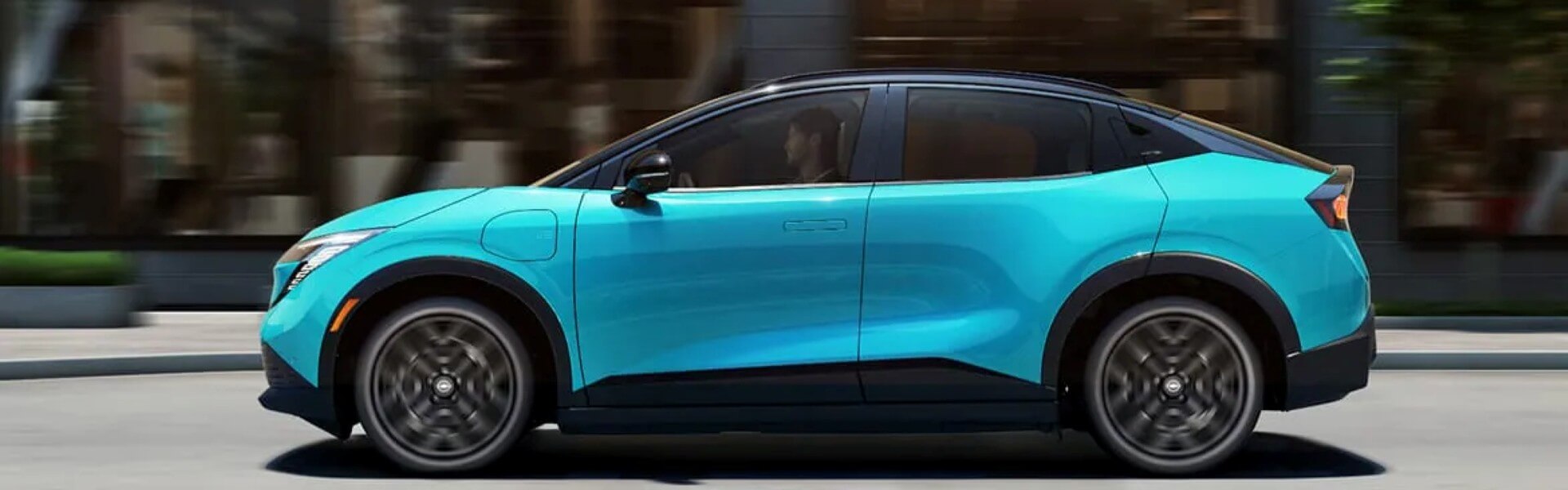 2026 Nissan LEAF driving down a city road Banner