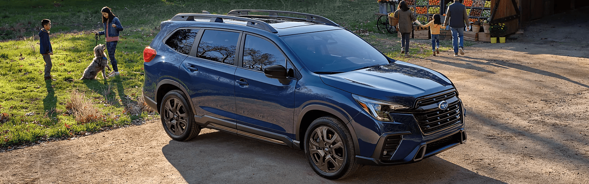 2026 Subaru Ascent With Family in Front of Farm Stand Banner