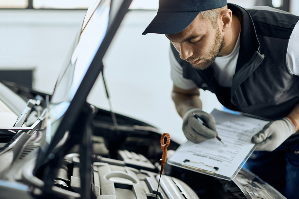 A man is checking the car's oil