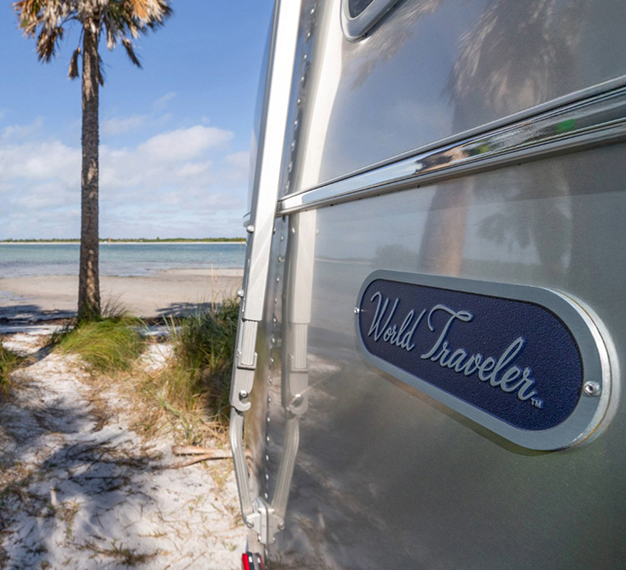 Airstream - closeup of side of trailer with the beach in the distance
