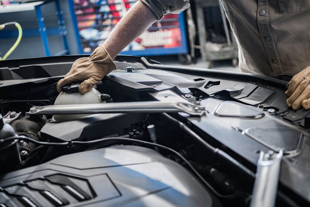 Car Mechanic Checking On Engine Coolant Level - Feature Image