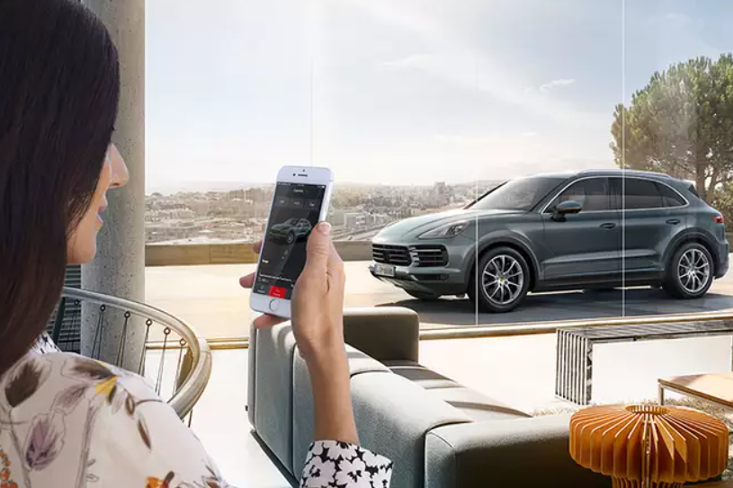 Customer using a smartphone to view details about a Porsche SUV Feature