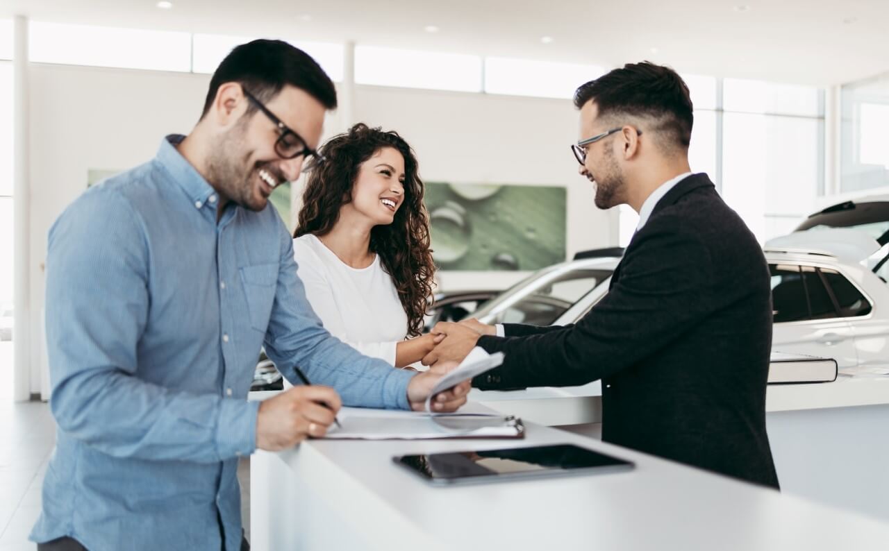 Financing - Couple Buying Car From Showroom Auto Dealer - Feature Image