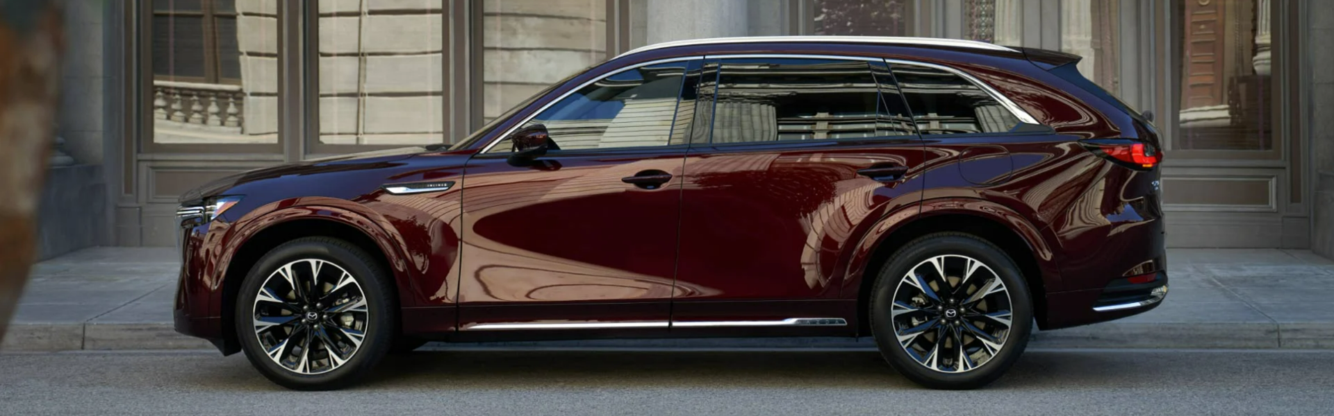 Mazda CX-90 in red parking on street side view