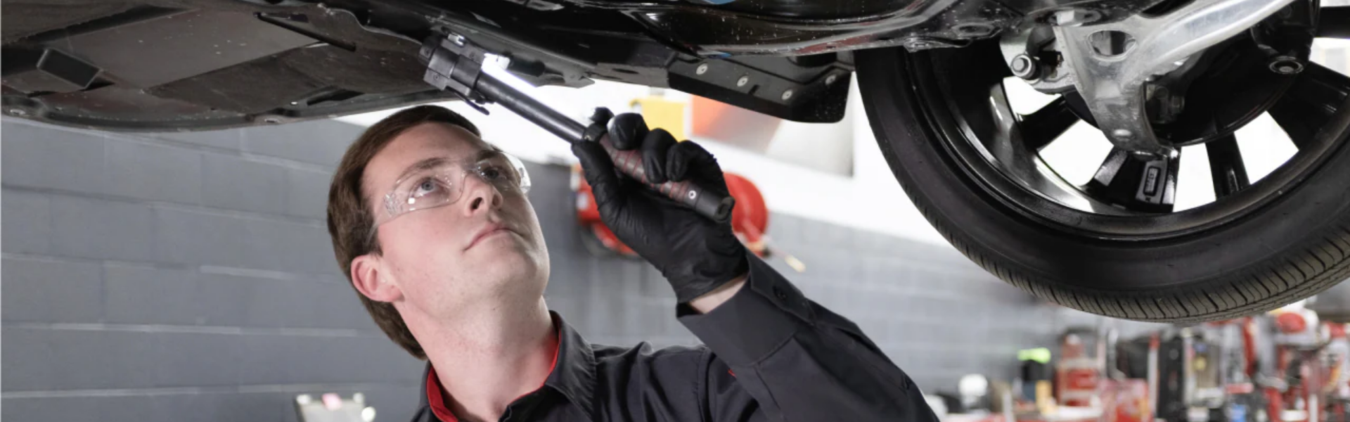 Nissan technician giving under the car inspection