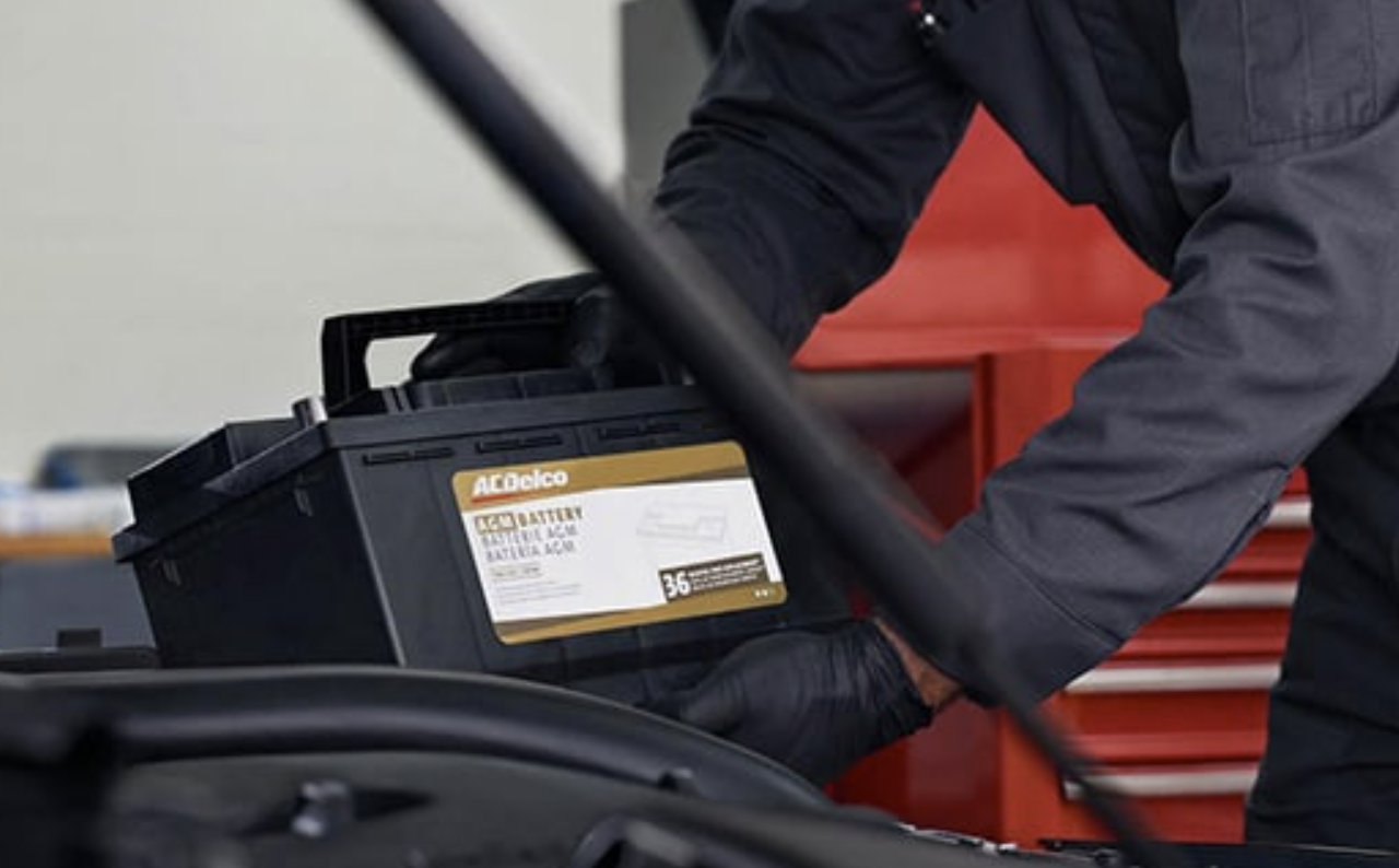 Technician replacing vehicle battery