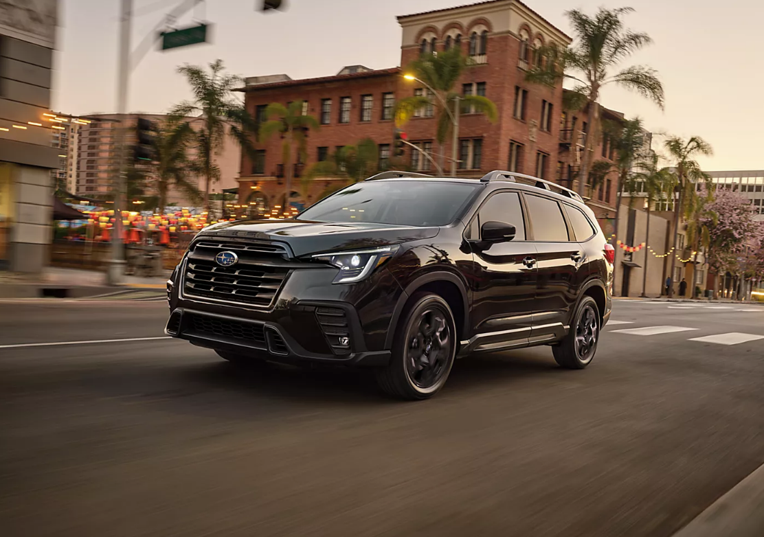 Used Subaru Ascent driving through an urban environment at dusk or early evening